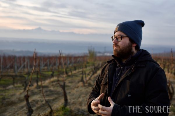 Mauro Marengo standing in vineyard landscape.