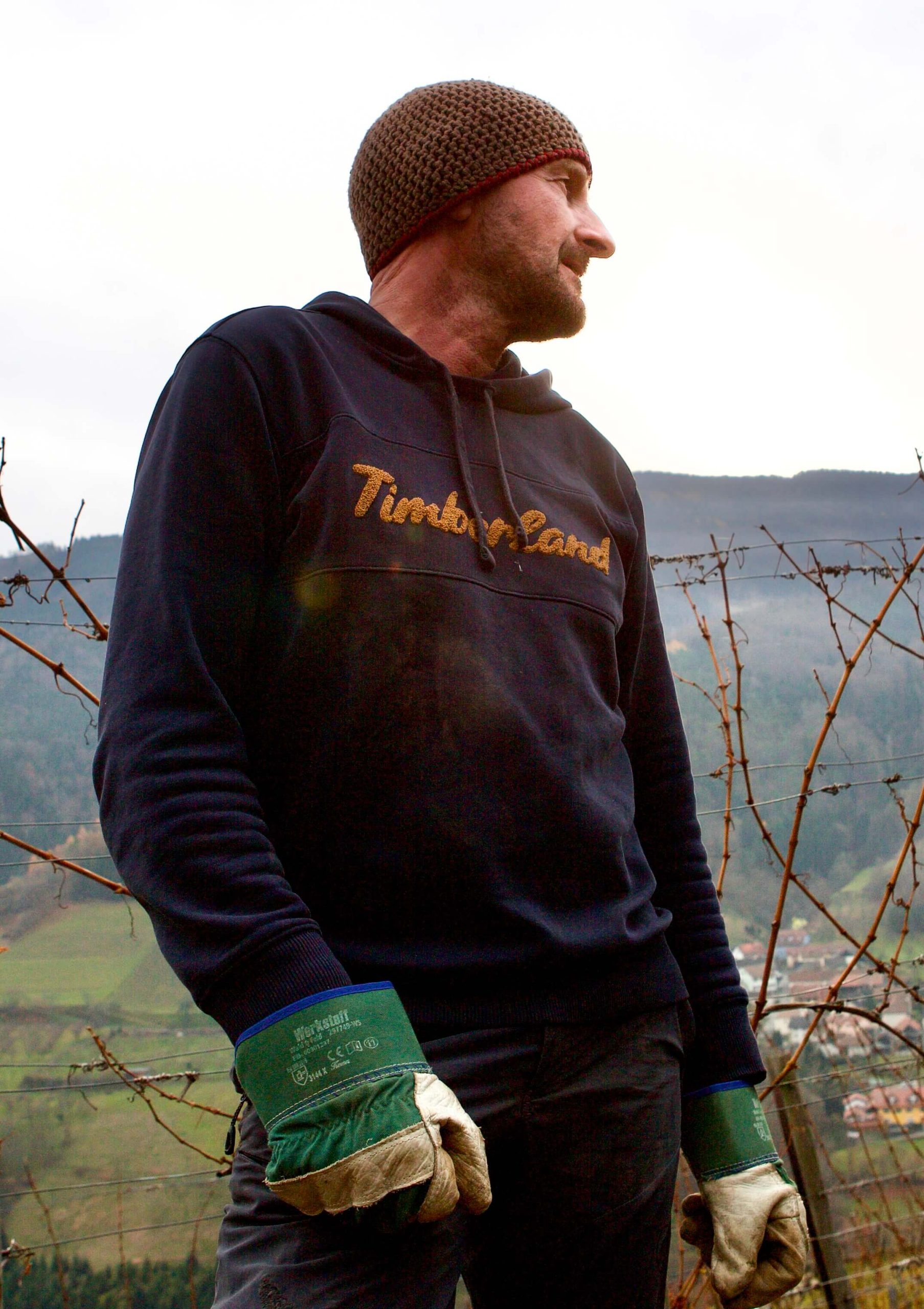 Martin Muthenthaler wearing gloves and a hat in the vineyard