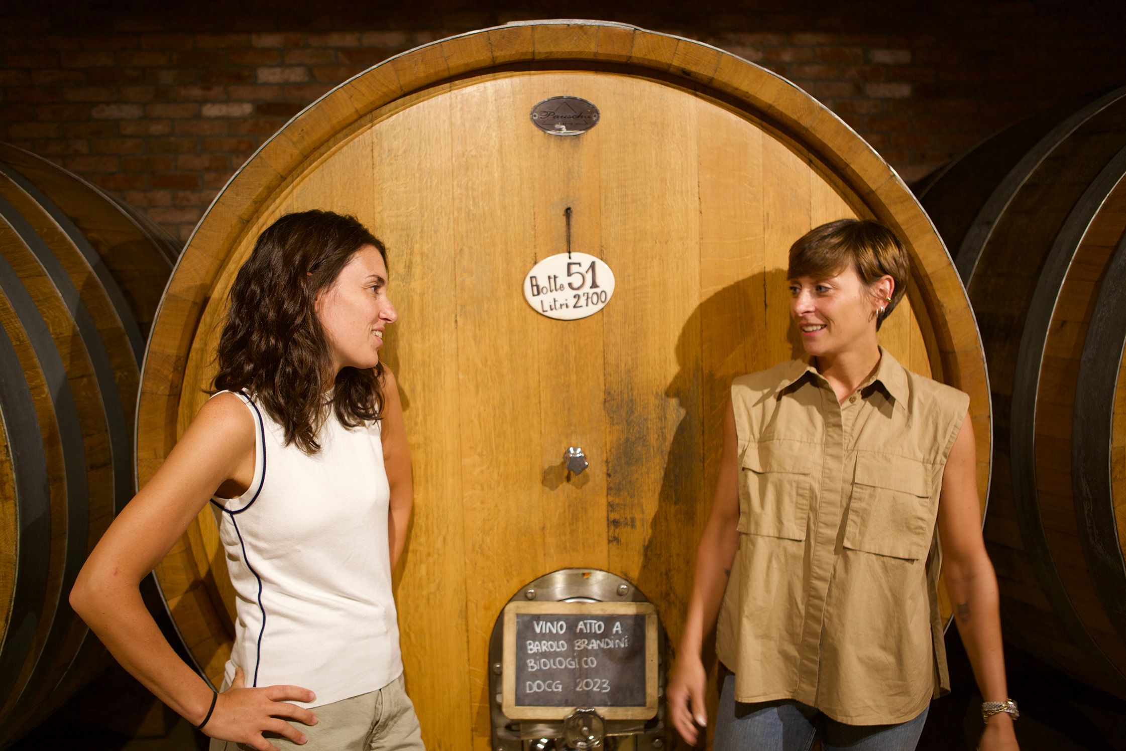 Giovanna and Serena Bagnasco next to a large wooden barrel