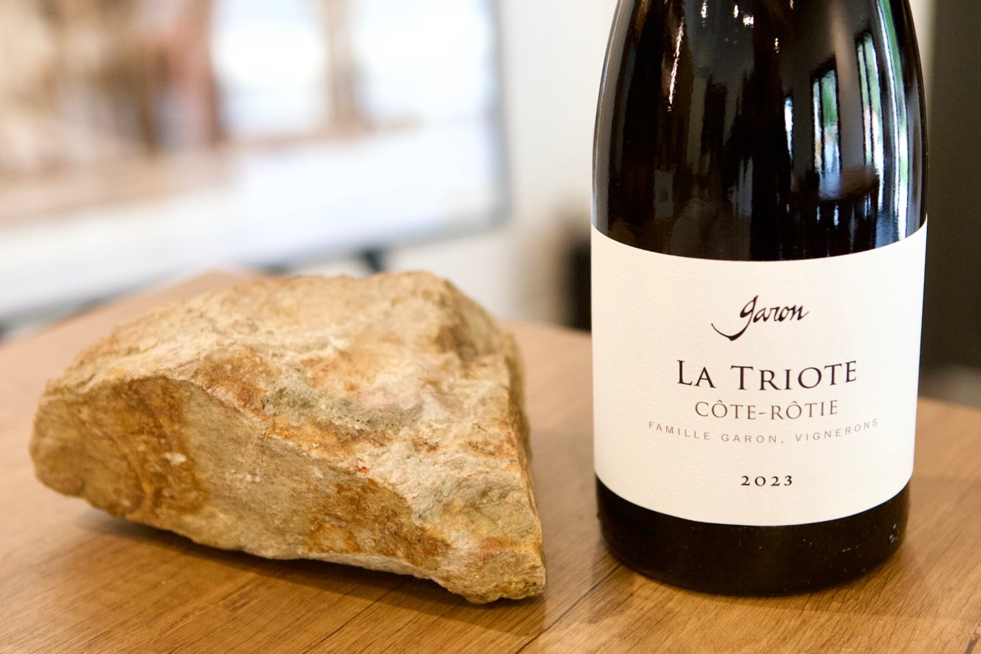 Bottle of Famille Garon Côte-Rôtie La Triote beside a rock